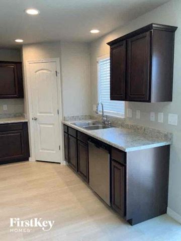 Colorado Springs house for rent - A kitchen with dark brown cabinets and a white door.