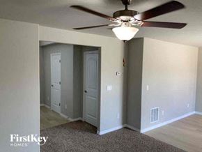Colorado Springs house for rent - A room with a ceiling fan and two doors.