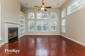 Moncks Corner house for rent - A spacious room with a fireplace and wooden floors.