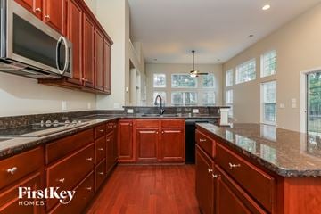 Moncks Corner house for rent - A kitchen with wooden cabinets and a FirstKey Homes logo.