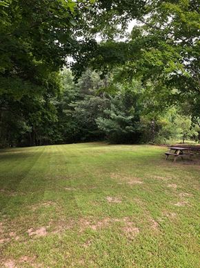 South Paris apartment for rent - A picnic table sits in a grassy field with trees in the background.