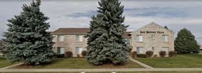 Sterling Heights apartment for rent - a stone building with two large trees in front of it