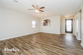 San Tan Valley house for rent - A spacious room with wooden flooring and a ceiling fan.