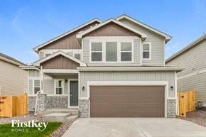 Colorado Springs house for rent - A modern two-story house with a garage door and a stone pillar.