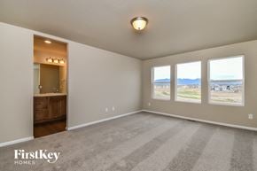 Colorado Springs house for rent - A spacious room with a carpeted floor and a view of the outdoors through the windows.