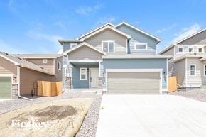 Colorado Springs house for rent - A row of houses with the first one being blue and the others being beige.