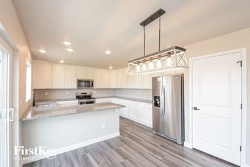 Colorado Springs house for rent - A modern kitchen with a stainless steel refrigerator and a hanging light fixture.