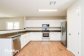 San Tan Valley house for rent - A kitchen with white cabinets and a refrigerator.
