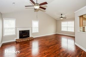 Midland house for rent - A spacious room with a fireplace and wood flooring.