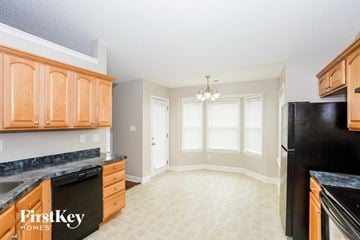 Midland house for rent - A kitchen with black appliances and wooden cabinets.