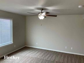 Colorado Springs house for rent - an empty bedroom with a ceiling fan and a window