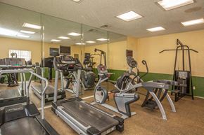 Santa Clarita apartment for rent - a gym with cardio equipment and mirrors on the wall