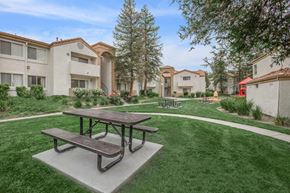Santa Clarita apartment for rent - a picnic area with benches in front of some apartments