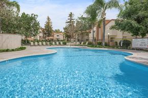 Santa Clarita apartment for rent - a large swimming pool with trees and buildings in the background