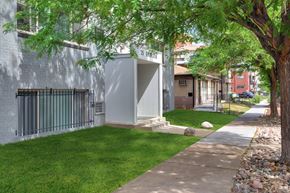Denver apartment for rent - a sidewalk in front of a building with grass and trees