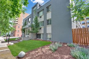 Denver apartment for rent - an exterior view of a building with green grass and trees