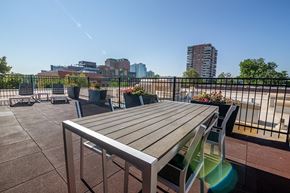 Denver apartment for rent - a patio with a table and chairs on a balcony with a view of the city