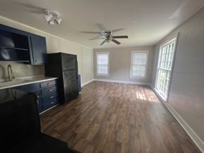 Hattiesburg apartment for rent - A kitchen with dark wood floors and a ceiling fan.