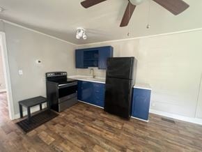 Hattiesburg apartment for rent - A kitchen with black appliances and blue cabinets.