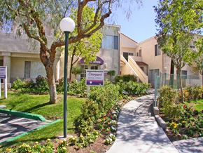 Santa Clarita apartment for rent - a sidewalk in front of an apartment building with a sign