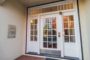 Oakland apartment for rent - A white door with a glass window and a red handle.