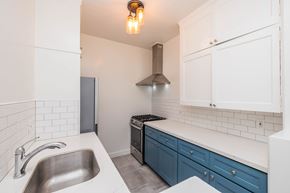 Oakland apartment for rent - A kitchen with a stainless steel sink and a stove top oven.