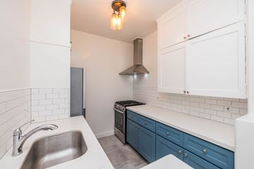 Oakland apartment for rent - A kitchen with a stainless steel sink and a stove top oven.
