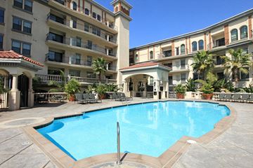 Los Angeles apartment for rent - A large swimming pool in front of a building with a balcony.