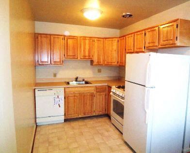 Arlington apartment for rent - a kitchen with white appliances and wooden cabinets