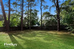Fuquay Varina house for rent - a backyard with tall trees and a fence