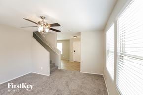 Gilbert house for rent - a living room with a ceiling fan and a carpeted staircase