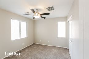 Gilbert house for rent - a bedroom with a ceiling fan and a door to a closet