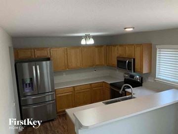 Colorado Springs house for rent - A kitchen with wooden cabinets and a stainless steel refrigerator.