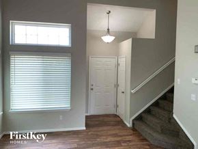 Colorado Springs house for rent - A staircase leads up to a door in a well-lit room.