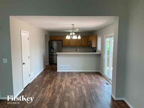 Colorado Springs house for rent - A kitchen with wooden floors and a white fridge.