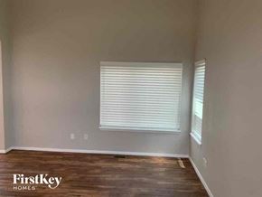 Colorado Springs house for rent - A room with wooden floors and a window with blinds.