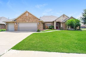 Oklahoma City house for rent - A brick house with a red door and a garage door.