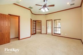 Oklahoma City house for rent - A spacious room with a ceiling fan and wooden doors.