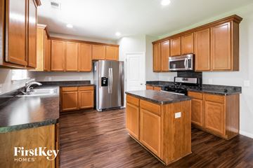 Goose Creek house for rent - A kitchen with wooden cabinets and a refrigerator.