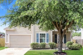 Houston house for rent - A tree in front of a house with a garage door.