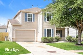 Houston house for rent - A two-story house with a garage and a tree in front.