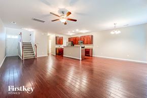 Summerville house for rent - a empty living room with a ceiling fan and a kitchen