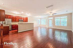 Summerville house for rent - an empty living room and kitchen with wood floors