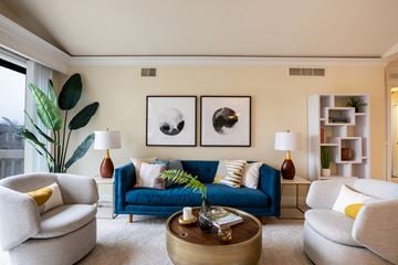Novi apartment for rent - a living room with a blue couch and chairs and a coffee table