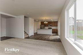 Colorado Springs house for rent - A spacious, empty room with a carpeted floor and a large window.