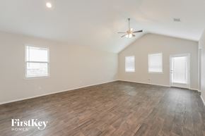 Conroe house for rent - A spacious room with wooden flooring and a ceiling fan.