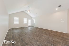 Conroe house for rent - A spacious room with wooden flooring and a ceiling fan.