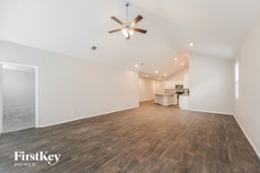 Conroe house for rent - A spacious room with wooden flooring and a ceiling fan.