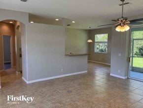 North Port house for rent - a large empty living room with a ceiling fan
