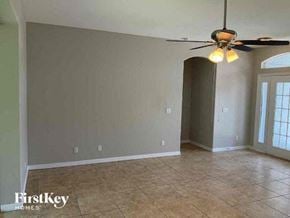 North Port house for rent - a empty living room with a ceiling fan and tiled floor